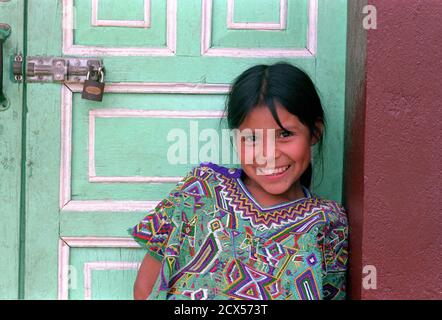 Ixil Maya fille devant les portes peintes de couleurs vives de la station de radio locale. Nebaj, triangle d'Ixil, El QuichŽ, Guatemala. Banque D'Images