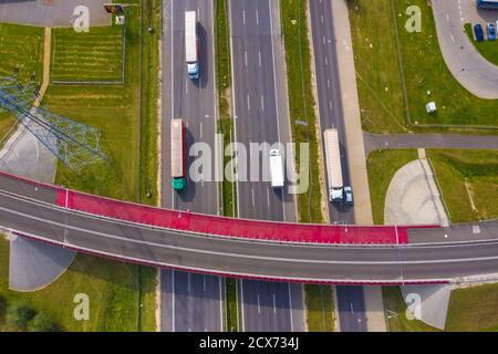 Antenne logistique du chariot. Les camions se mettent en mouvement par la route d'intersection entre les champs. Vue de drone. Banque D'Images