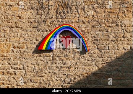 Arc-en-ciel peint sur du bois monté sur le mur de grès Banque D'Images