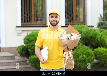 Liveur avec bouquet de belles fleurs à l'extérieur Banque D'Images