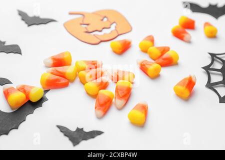 Composition pour Halloween avec de savoureux cornes de bonbons sur fond blanc Banque D'Images