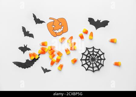 Composition pour Halloween avec de savoureux cornes de bonbons sur fond blanc Banque D'Images