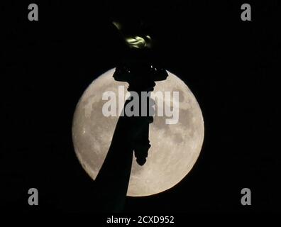 Jersey City, États-Unis. 30 septembre 2020. Une lune presque pleine s'élève derrière la torche de la Statue de la liberté à Jersey City le mercredi 30 septembre 2020. Photo de John Angelillo/UPI crédit: UPI/Alay Live News Banque D'Images