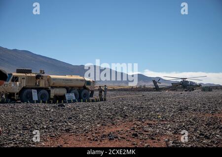 Spécialiste de l'approvisionnement en pétrole (92F) de l'escadron de cavalerie Echo 2-6, 25e Brigade de l'aviation de combat, 25e Division d'infanterie, approvisionnent les Apaches de Longbow AH-64D au FARP à 4 points lors d'une fusillade aérienne dans la zone d'entraînement de Pōhakuloa, à Hawaï. Le point d'armement et de ravitaillement avant (FARP) est conçu pour fournir le carburant et l'ordnance nécessaires pour les opérations d'hélicoptère et d'aile fixe hautement mobiles et flexibles. (É.-U. Photo de l'armée par le Sgt. Sarah D. Sangster) Banque D'Images