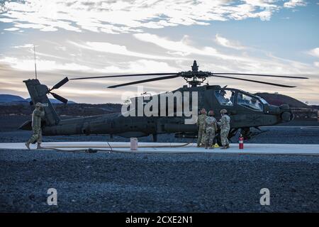 Spécialiste de l'approvisionnement en pétrole (92F) de l'escadron de cavalerie Echo 2-6, 25e Brigade de l'aviation de combat, 25e Division d'infanterie, approvisionnent les Apaches de Longbow AH-64D au FARP à 4 points lors d'une fusillade aérienne dans la zone d'entraînement de Pōhakuloa, à Hawaï. Le point d'armement et de ravitaillement avant (FARP) est conçu pour fournir le carburant et l'ordnance nécessaires pour les opérations d'hélicoptère et d'aile fixe hautement mobiles et flexibles. (É.-U. Photo de l'armée par le Sgt. Sarah D. Sangster) Banque D'Images