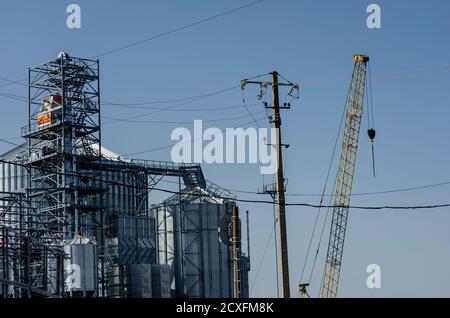 Processus de construction d'un terminal de grain moderne dans le port maritime. Silos cylindriques en métal pour la réception et le stockage de marchandises en vrac de grain. Exportation de grain. Banque D'Images