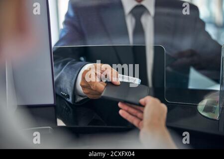 Homme qui donne des documents pour l'enregistrement à l'aéroport Banque D'Images