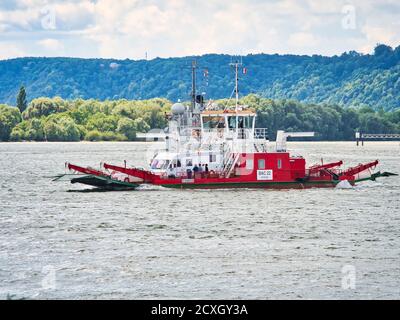 YAINVILLE, FRANCE - JUILLET Circa, 2019. Ferry rouge traversant la Seine avec des voitures. Avec le fond de la forêt, Banque D'Images