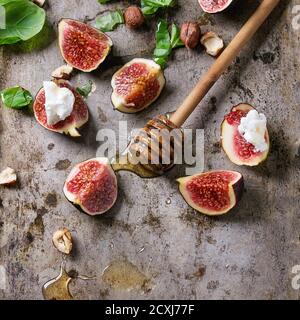 Figues fraîches en tranches avec ricotta, feuilles de basilic, noisette et miel de miel sur fond de métal rouillé foncé. Espace pour le texte. Im. Carré Banque D'Images