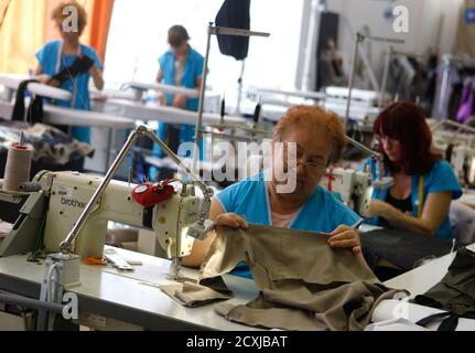 Seamstresses work at a garment assembly factory of Kezmu, a ...