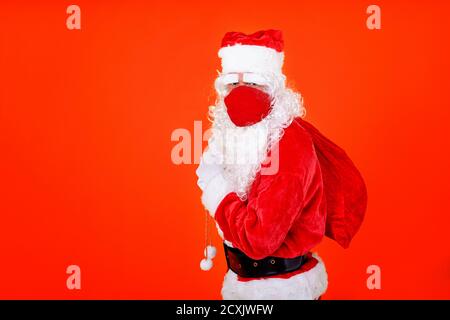 le père noël portant un masque rouge dans le Covid de Noël 19 heure Banque D'Images