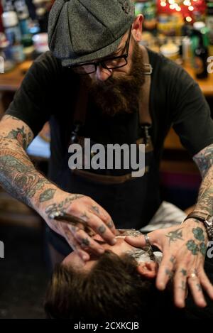 Coiffeur rasage de la barbe de l'homme en salon Banque D'Images