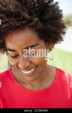 Portrait d'une jeune femme souriante debout dans le parc Banque D'Images