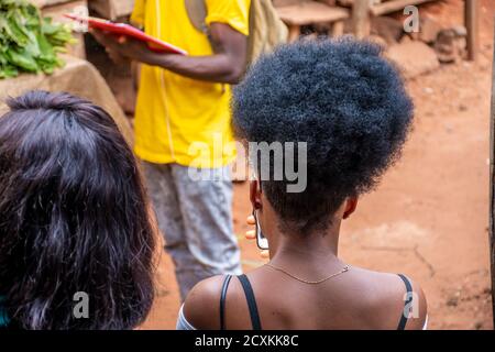 vue arrière d'une jeune femme africaine avec une afro un petit pain à l'extérieur avec son téléphone Banque D'Images