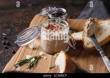 Bocaux de pâté de foie de poulet avec de la confiture de cassis et grains de grenade, des tranches de pain, servi avec vintage couteau sur planche en bois plus da Banque D'Images