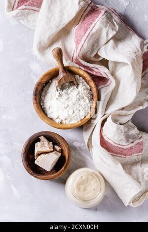 Levain de seigle et de blé en pots de verre, levure fraîche et instantanée, bol en bois d'olive de farine pour cuire du pain maison. Avec cuillère, table de service, cuisine Banque D'Images
