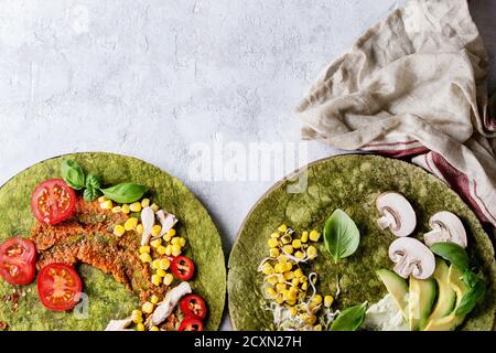 Tortillas au matcha aux épinards verts avec des ingrédients pour le remplissage prêt à emballer. Maïs, avocat, paprika vert, pousses, champignons, poulet, viande servie Banque D'Images