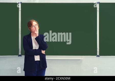 Un enseignant d'école se tient sans doute devant un tableau noir vide, un espace de copie pour l'inscription. Problèmes d'apprentissage via Internet pendant le Banque D'Images