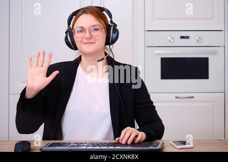 La caméra pour ordinateur portable capture une femme de race blanche dans un costume noir, interface de chat pour les appels vidéo. Fille de bienvenue à une conférence en ligne pour le travail à distance via Banque D'Images