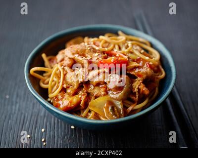bol de nouilles et de légumes frits avec sauce au poulet chaud sur la table du restaurant, cuisine chinoise Banque D'Images