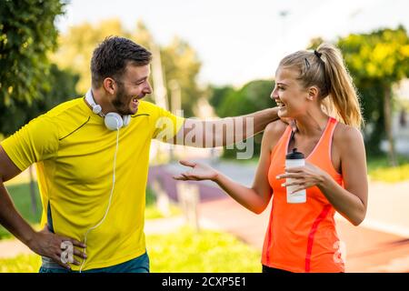 Un jeune couple fait de l'exercice en plein air. Ils s'étirent et s'échauffent pour le jogging. Banque D'Images