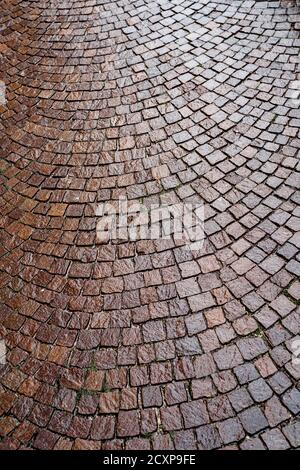 La texture d'une rue pavée brune humide de la pluie. Banque D'Images