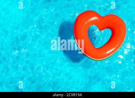 Bouée gonflable à coeur rouge nagez dans la vue sur la piscine par le haut Banque D'Images