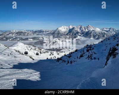 Vue panoramique sur les montagnes enneigées du Lofer (à droite) et ski Pentes de Fieberbrunn dans les alpes de l'Austrain contre le ciel bleu Banque D'Images