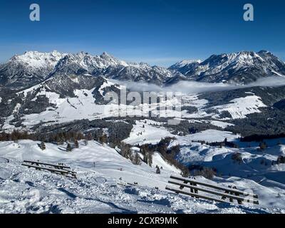 Vue panoramique sur les montagnes enneigées du Lofer (à gauche), les montagnes du Leogang et les pistes de ski de Fieberbrunn dans les alpes de l'Austrain contre un ciel bleu Banque D'Images