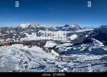 Vue panoramique sur les montagnes enneigées du Lofer (à gauche), les montagnes du Leogang et les pistes de ski de Fieberbrunn dans les alpes de l'Austrain contre un ciel bleu Banque D'Images