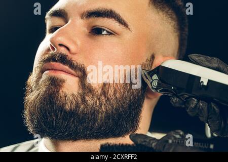 Client Barbershop. Homme taillé sa barbe avec un rasoir électrique Banque D'Images