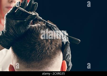 Coupe courte de cheveux de barbier du client avec des ciseaux Banque D'Images