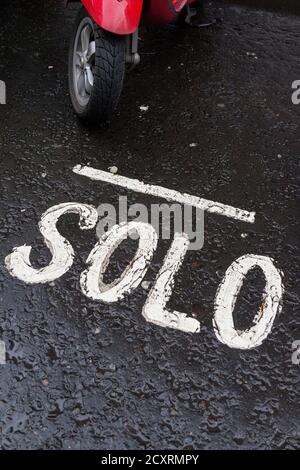 Panneau sur la surface de la route indiquant que la zone est réservée au stationnement des motos solo uniquement . Le quartier de Soho dans le West End de Londres lors d’un mois de janvier froid et humide Banque D'Images