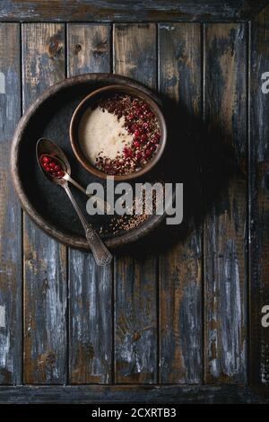 Bol de céréales au lait d'avoine avec des additifs de graines de lin, de chocolat et de baies plus vieille planche en bois. Vue de dessus avec l'espace Banque D'Images