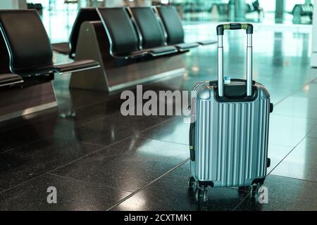 Une valise dans un salon de départ d'aéroport vide. Concept de voyage et de vacances. Banque D'Images