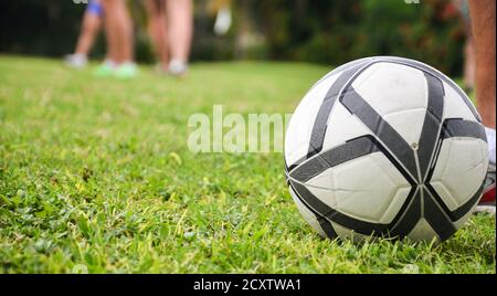 Terrain de football, ballon sur l'herbe, les pieds des hommes. Arrière-plan flou Banque D'Images