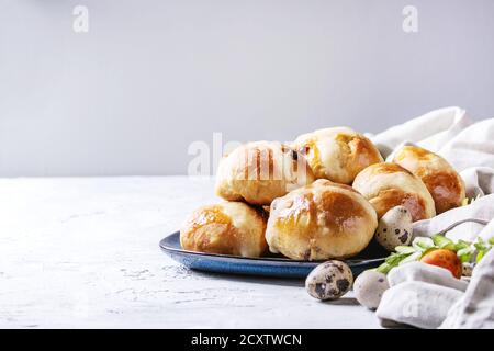 Traditionnel de Pâques faits maison les brioches sur plaque bleue avec des oeufs de cailles et de couleur blanche sur fond de texture. Copy space Banque D'Images