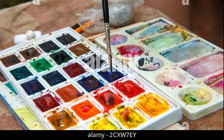 L'artiste plonge un pinceau dans des peintures à l'huile. Palette peintures à l'huile Banque D'Images