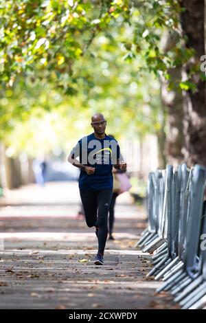 Un coureur sur la route du 40ème marathon de Londres qui aura lieu sur un circuit en boucle fermée autour de St James's Park dans le centre de Londres. Les athlètes participant aux courses d'élite pour hommes, femmes et fauteuils roulants participeront à un cours en boucle fermé dans le parc St James's, dans une bulle de biosecure. Banque D'Images