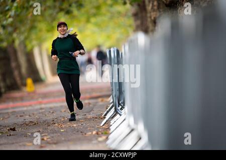 Un coureur sur la route du 40ème marathon de Londres qui aura lieu sur un circuit en boucle fermée autour de St James's Park dans le centre de Londres. Les athlètes des épreuves de menÕs, womenÕs et de l'élite des fauteuils roulants participeront à un cours en boucle fermé dans le parc St JamesÕs, dans une bulle de biosecure. Banque D'Images