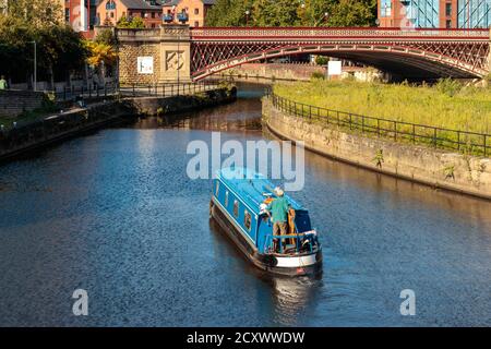 Vue sur des personnes non identifiées et un bateau de canal naviguant sur l'écluse de l'île de la rivière aire, Leeds Banque D'Images