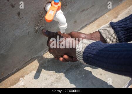 Gros plan des mains lavées sur une prise publique Banque D'Images