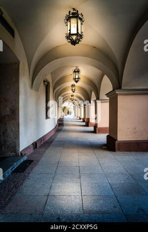 Arcades ou arcades avec long couloir illuminé par des lanternes d'époque. Bâtiment Townhall sur la place de la ville à Kielce, Pologne Banque D'Images