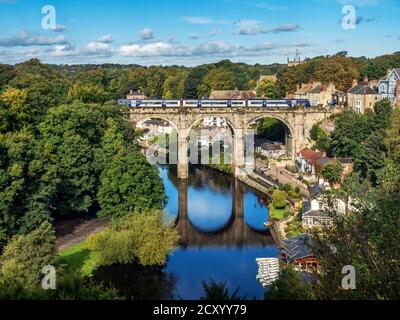 Train de voyageurs traversant le viaduc de chemin de fer victorien de l'autre côté de la rivière Nidd au début de l'automne Knaresborough North Yorkshire England Banque D'Images