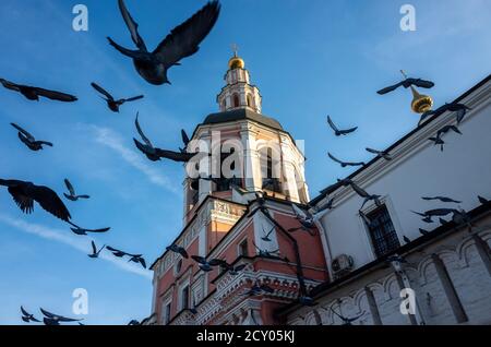 Un troupeau de pigeons s'envolée sur le fond du clocher d'une église orthodoxe. Banque D'Images