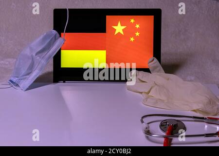 Infection à Corona-virus 2019-nCoV en allemagne en provenance de chine représentée par le drapeau allemand et le drapeau chinois, masque médical comme protection et un stéthoscope Banque D'Images