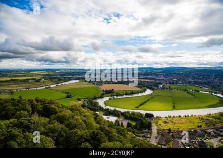 Vue sur le fleuve avec arbres et maisons au premier plan et les montagnes Banque D'Images