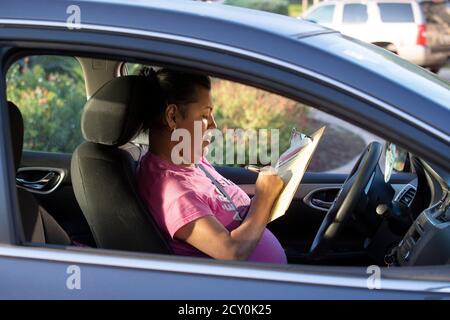 Austin, Texas, États-Unis. 1er octobre 2020. Irma Flores, une résidente d'Austin, remplit une demande d'inscription des électeurs, car les travailleurs des organismes de bienfaisance catholiques aident les résidents du Texas à vérifier le statut d'inscription des électeurs et à les aider avec les demandes des électeurs pendant un trajet de quatre heures le 1er octobre 2020 à Austin. Plusieurs dizaines de résidents américains majoritairement hispaniques ont été inscrits dans l'effort non partisan. Crédit : Bob Daemmrich/Alay Live News Banque D'Images