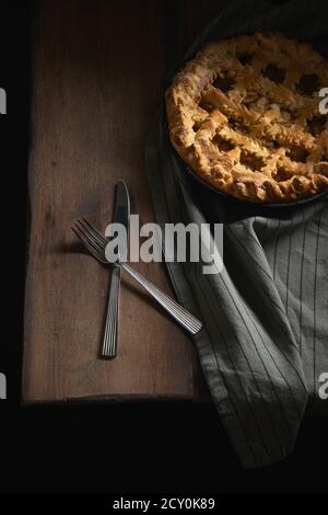 Tarte aux pommes maison rustique dans une poêle en fonte et couverts Banque D'Images