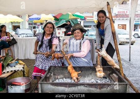 Cuenca, Équateur - Mars 13, 2016 - Trois femmes cuy barbecue pour le déjeuner à un festival en plein air Banque D'Images